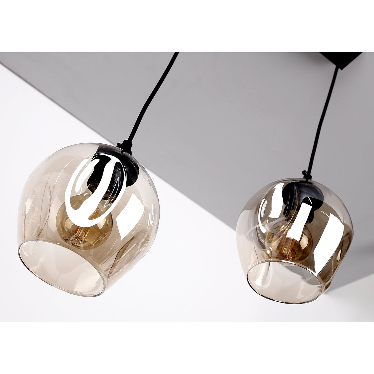 Gros plan plongeant sur les deux diffuseurs en verre ambré et leurs reflets.