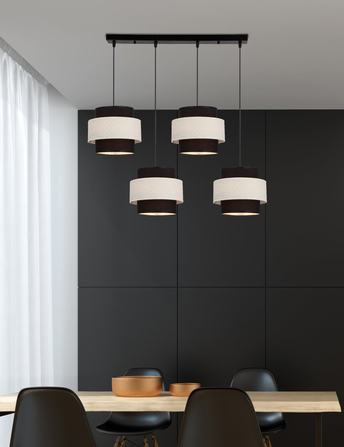 Suspension quatre lumières noire et crème installée au-dessus d'une table à manger en bois