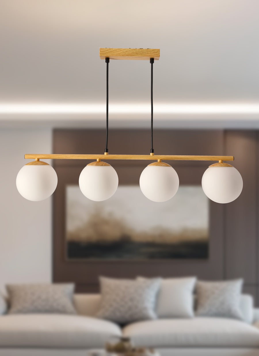 Luminaire suspendu devant un canapé beige et un tableau encadré, intérieur chaleureux.