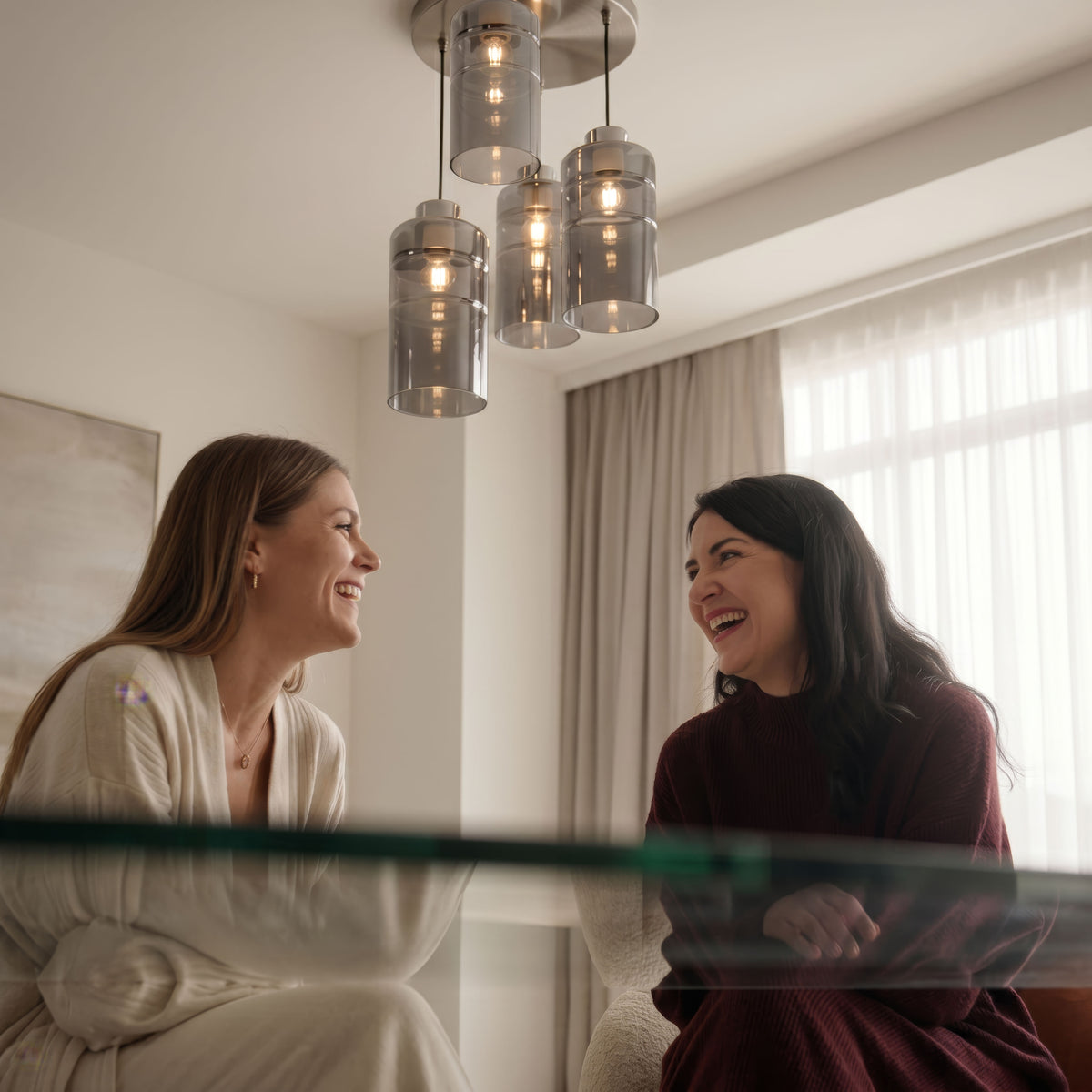 Mise en ambiance deux femmes discutant sous le luminaire au-dessus d'une table