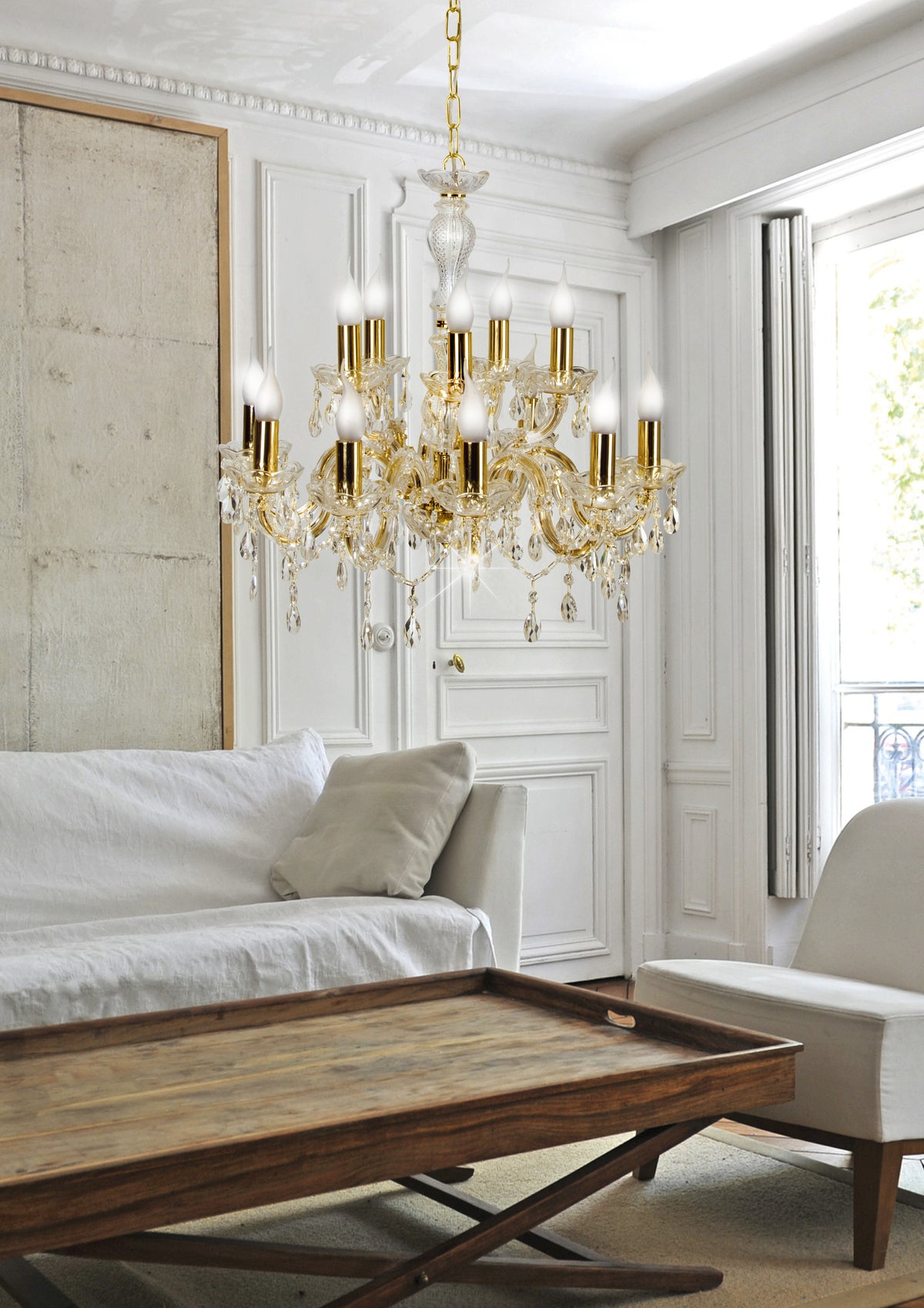 Suspension dorée allumée dans un salon blanc avec canapé, table basse et fenêtres