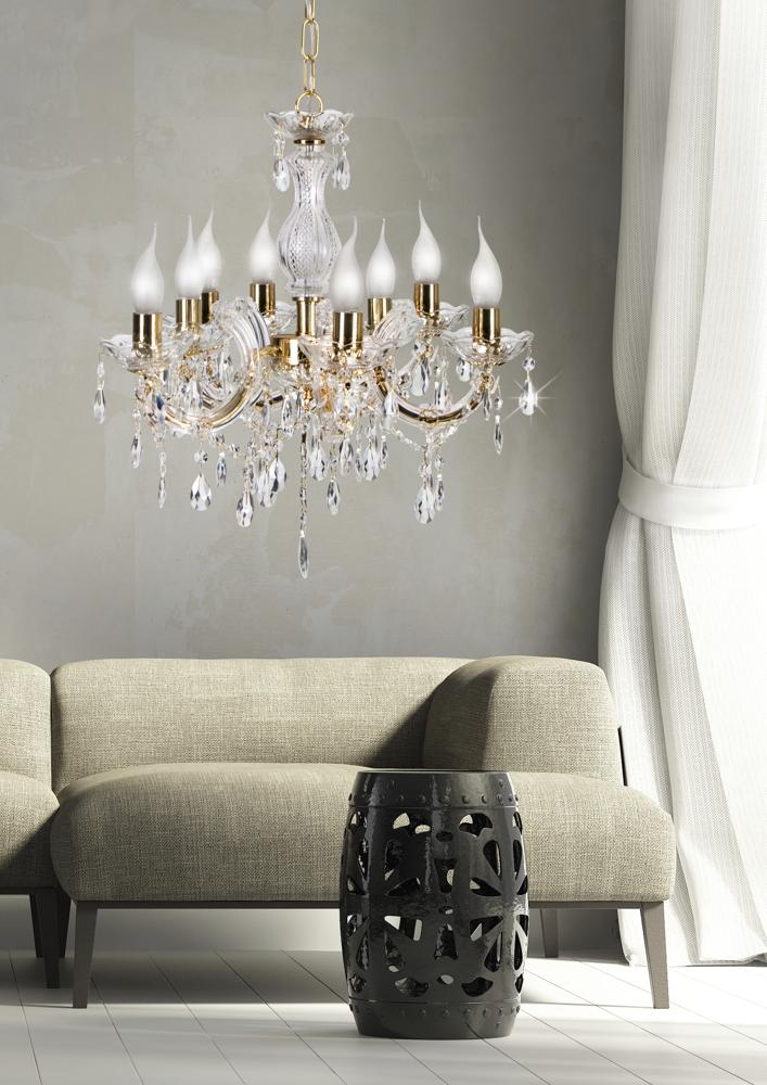 Vue rapprochée du luminaire allumé, avec canapé beige et tabouret noir découpé.