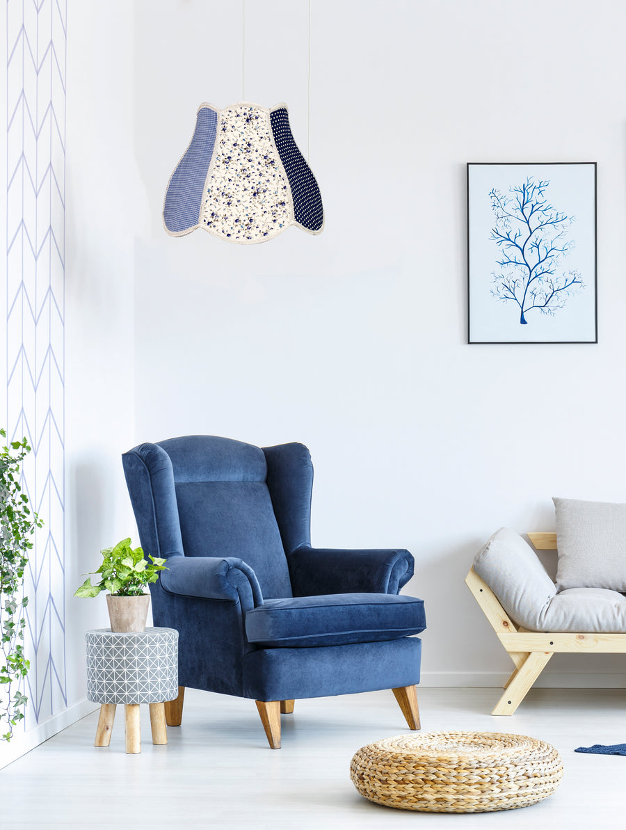 Suspension bleue suspendue dans un salon bleu et blanc avec fauteuil et tableau.