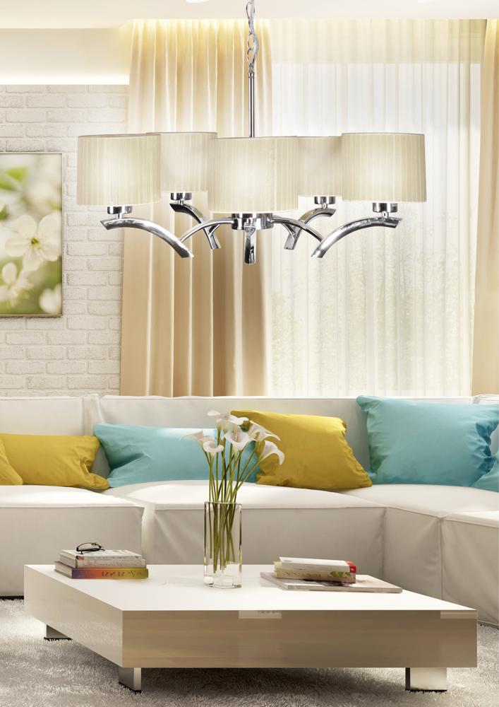 Vue rapprochée du lustre au-dessus du salon, abat-jours crème et bras métal poli