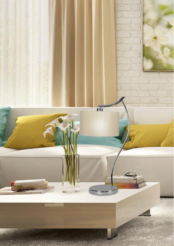 Vue rapprochée en intérieur, abat-jour crème allumé et tige chromée courbée sur table basse