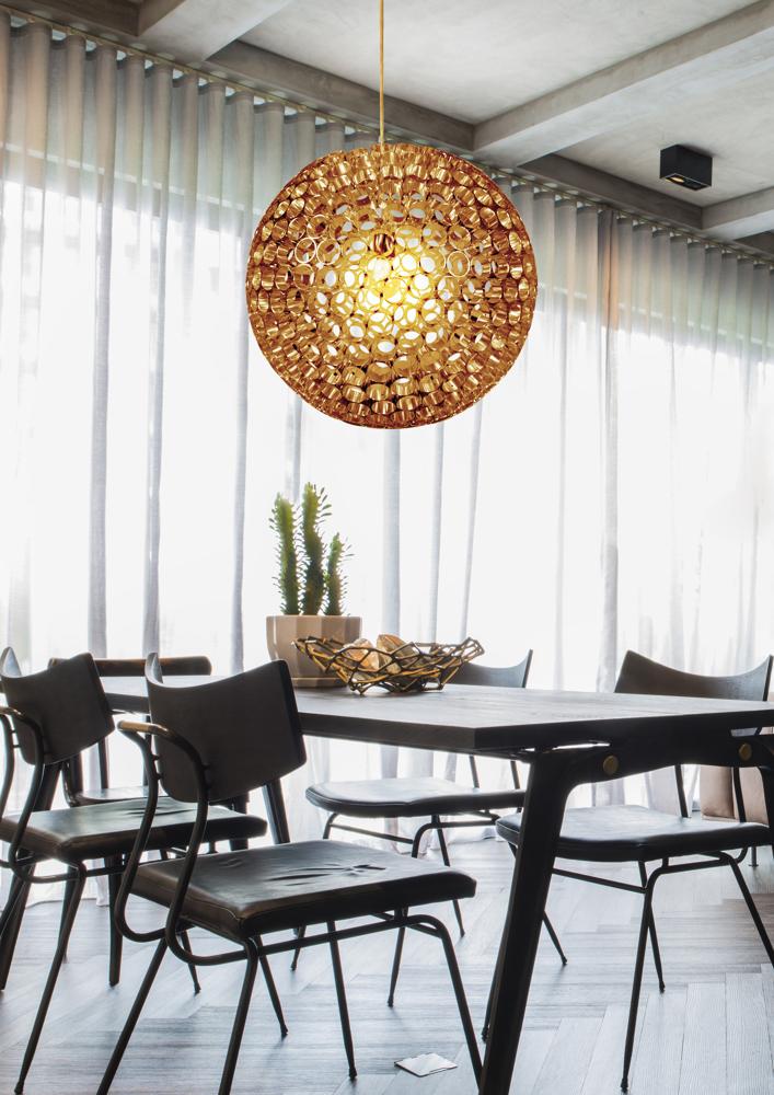Plan rapproché du lustre allumé au-dessus du mobilier sombre dans une pièce claire