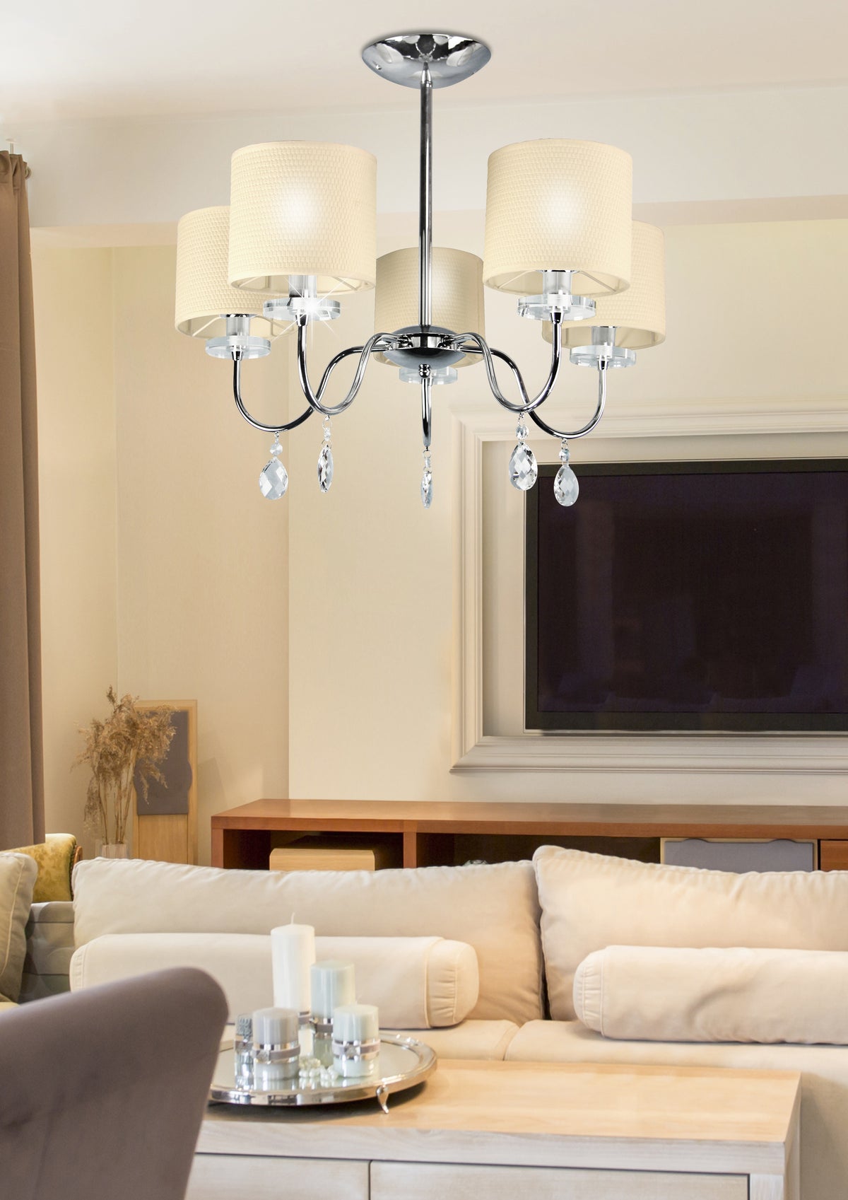 Mise en ambiance salon contemporain avec la suspension allumée au-dessus du canapé beige