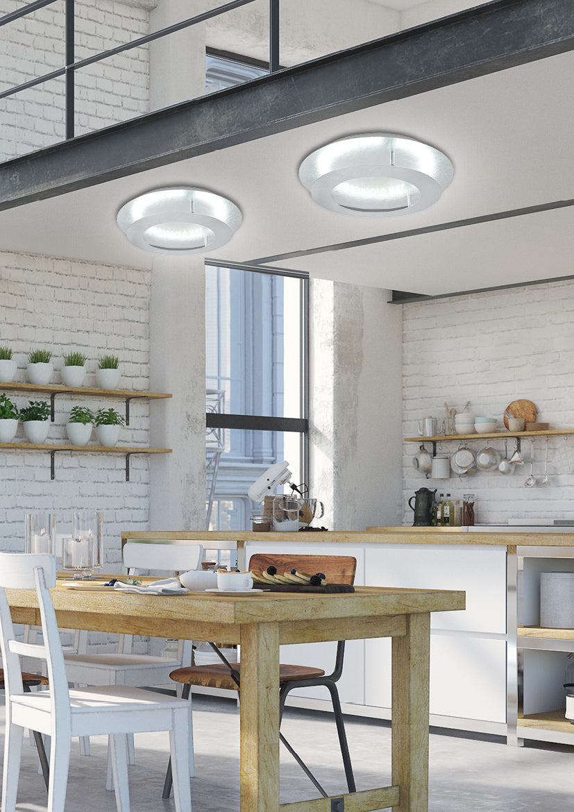 Deux plafonniers ronds éclairant un loft industriel à cuisine ouverte