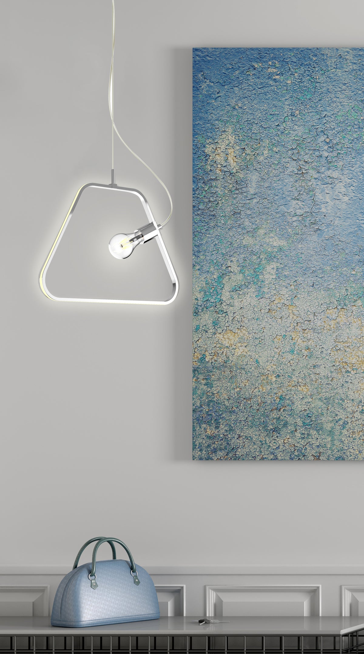 Le luminaire chromé allumé, présenté près d'une peinture et d'un sac
