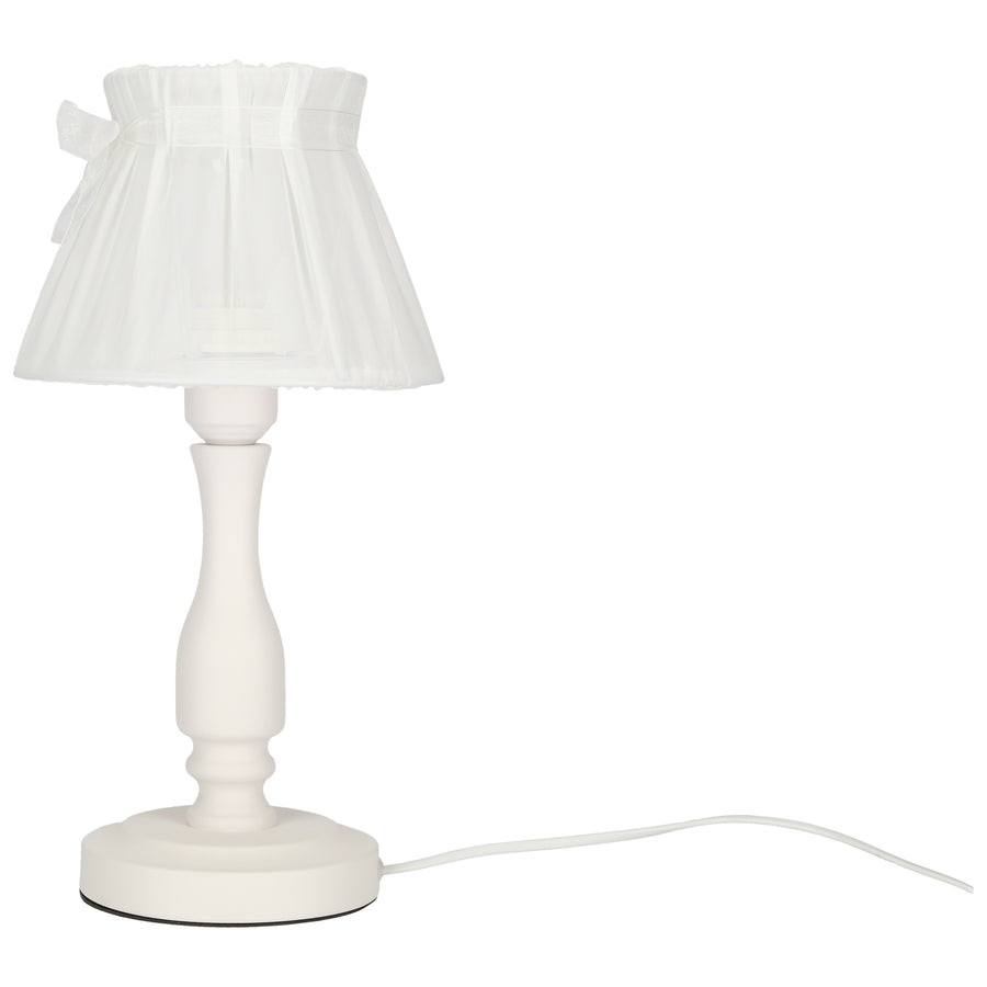 Lampe à poser blanche, vue de trois quarts, cordon d'alimentation blanc visible au sol.