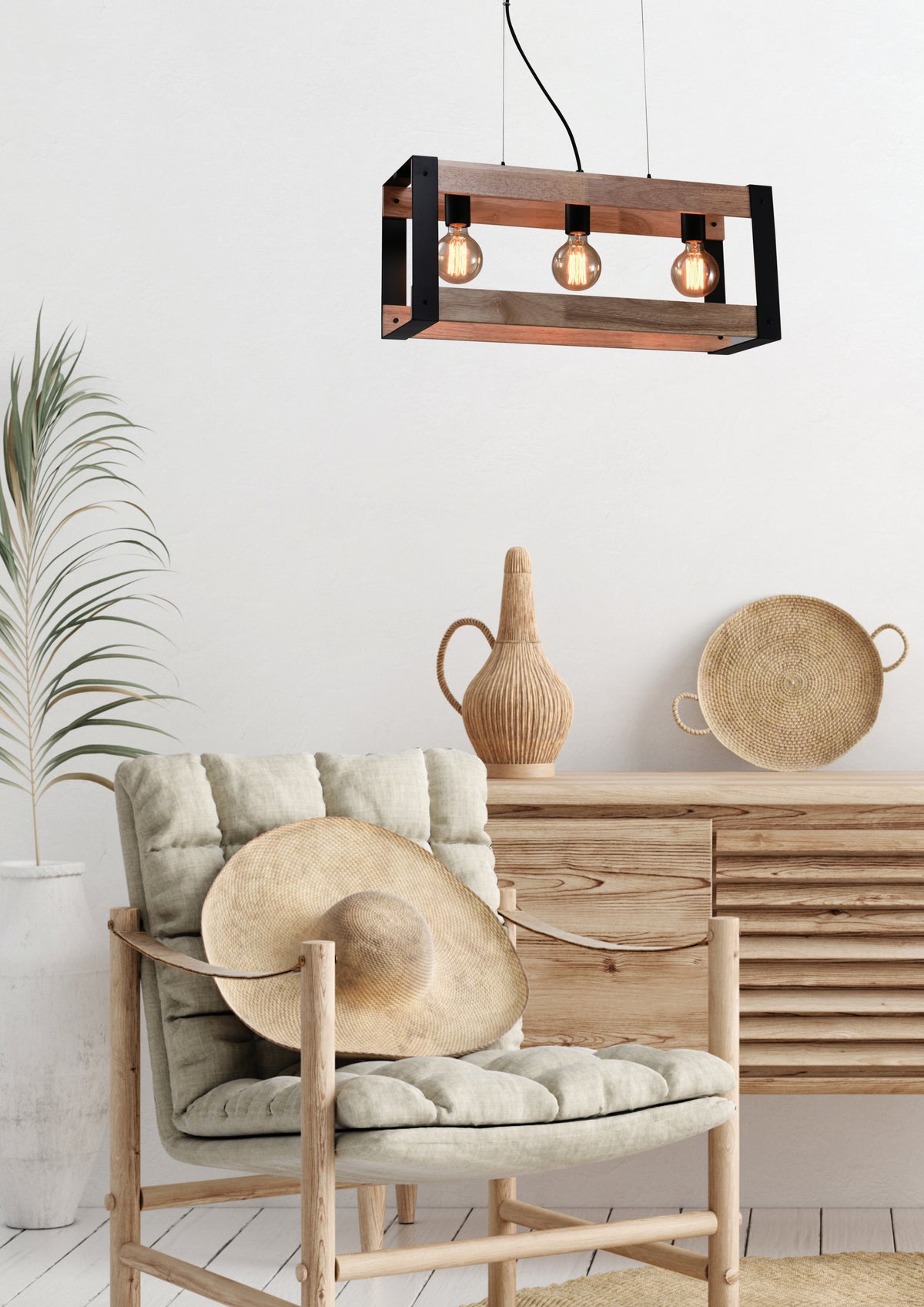 Mise en ambiance du luminaire suspendu dans un salon épuré, fauteuil en bois et jonc tressé.