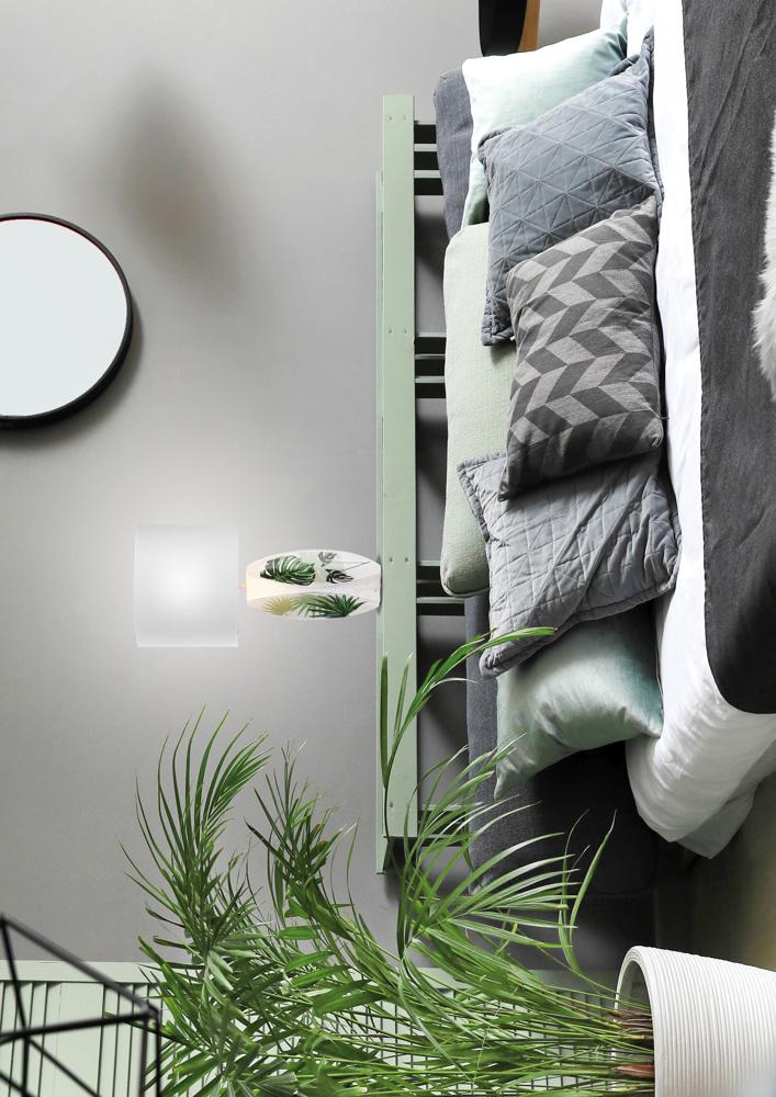 Lampe allumée vue de profil, lumière douce près d'une grande plante et d'un miroir rond