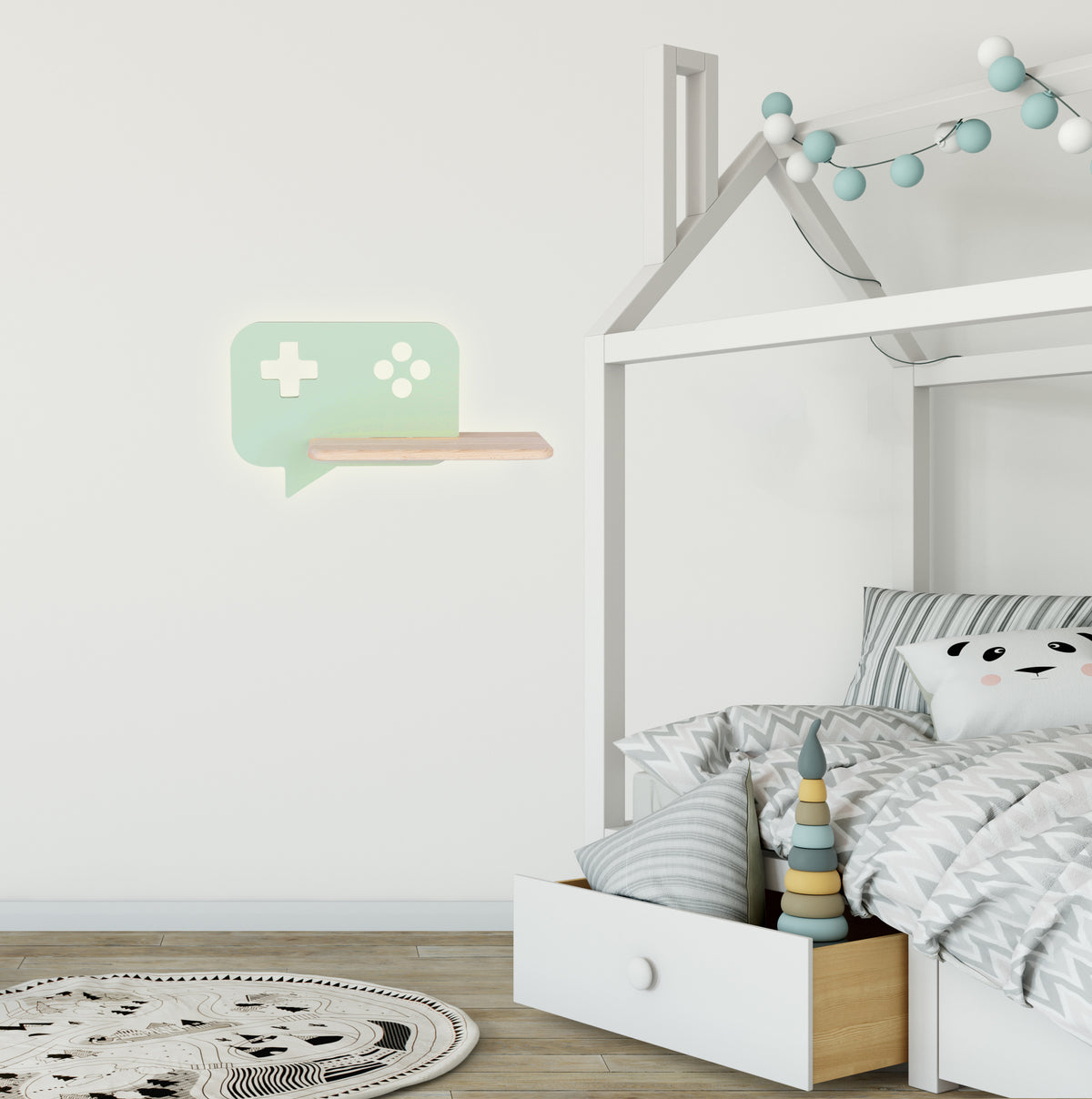 Vue de la lampe murale au-dessus d'un lit cabane, avec guirlande lumineuse et jouets.