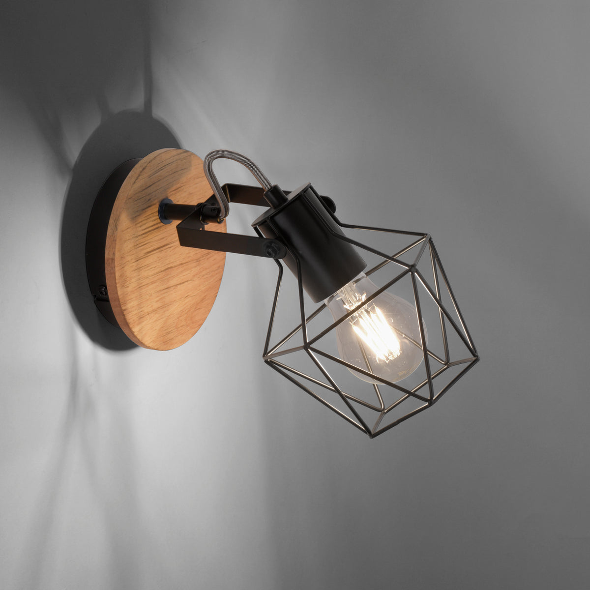 Gros plan sur la cage métallique, ampoule allumée projetant des ombres sur le mur