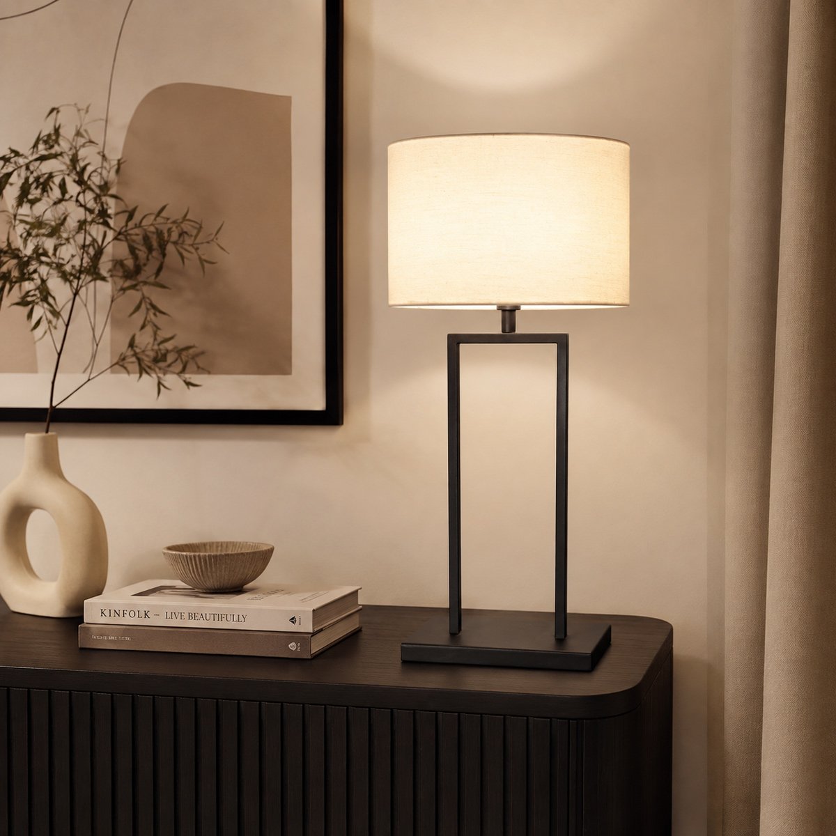 Lampe allumée posée sur un meuble noir dans un intérieur chaleureux