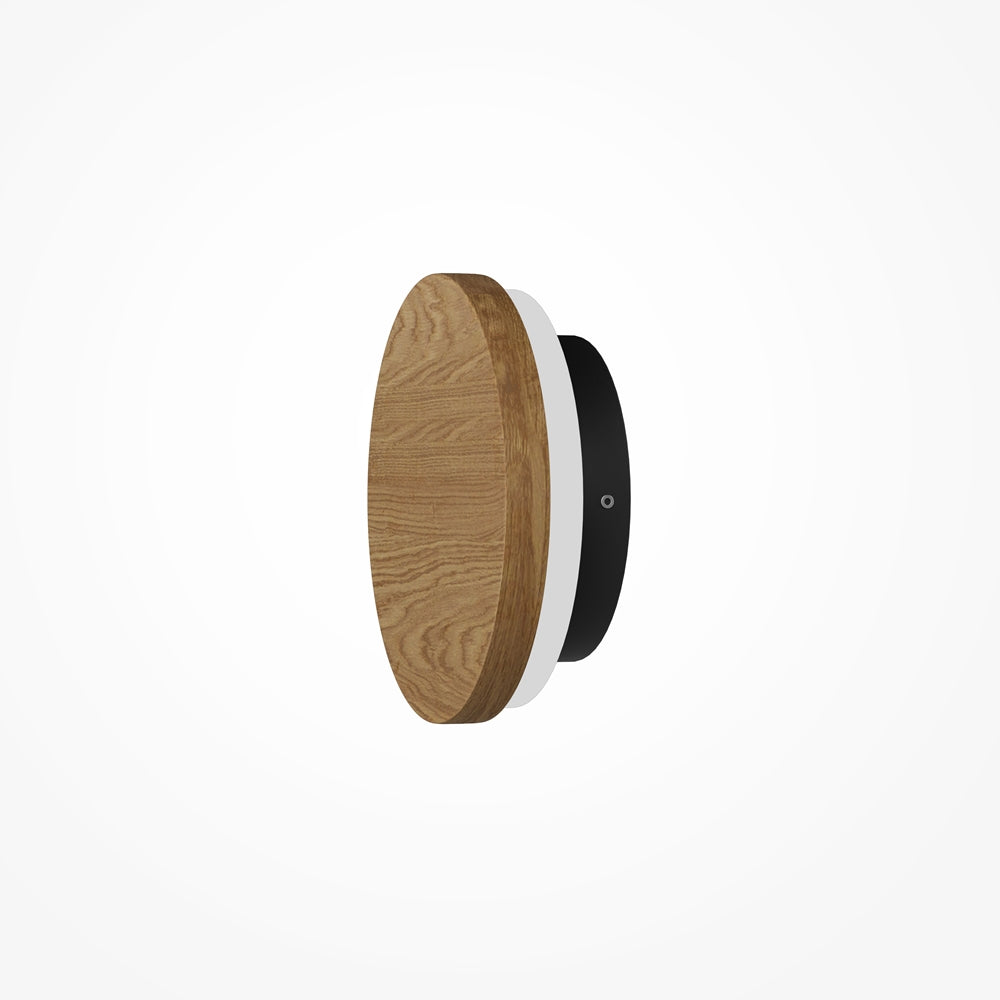 Vue de profil du luminaire mural : disque bois, anneau blanc, base noire.