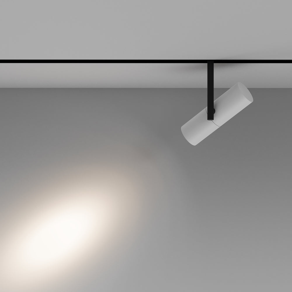 Mise en ambiance montrant le projecteur blanc sur rail éclairant une surface grise.