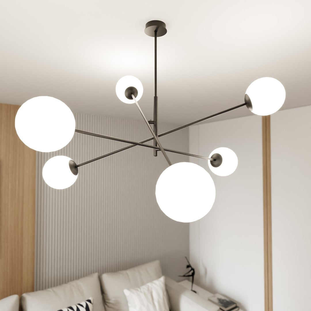 Suspension allumée au plafond, six globes blancs, intérieur moderne avec canapé clair.