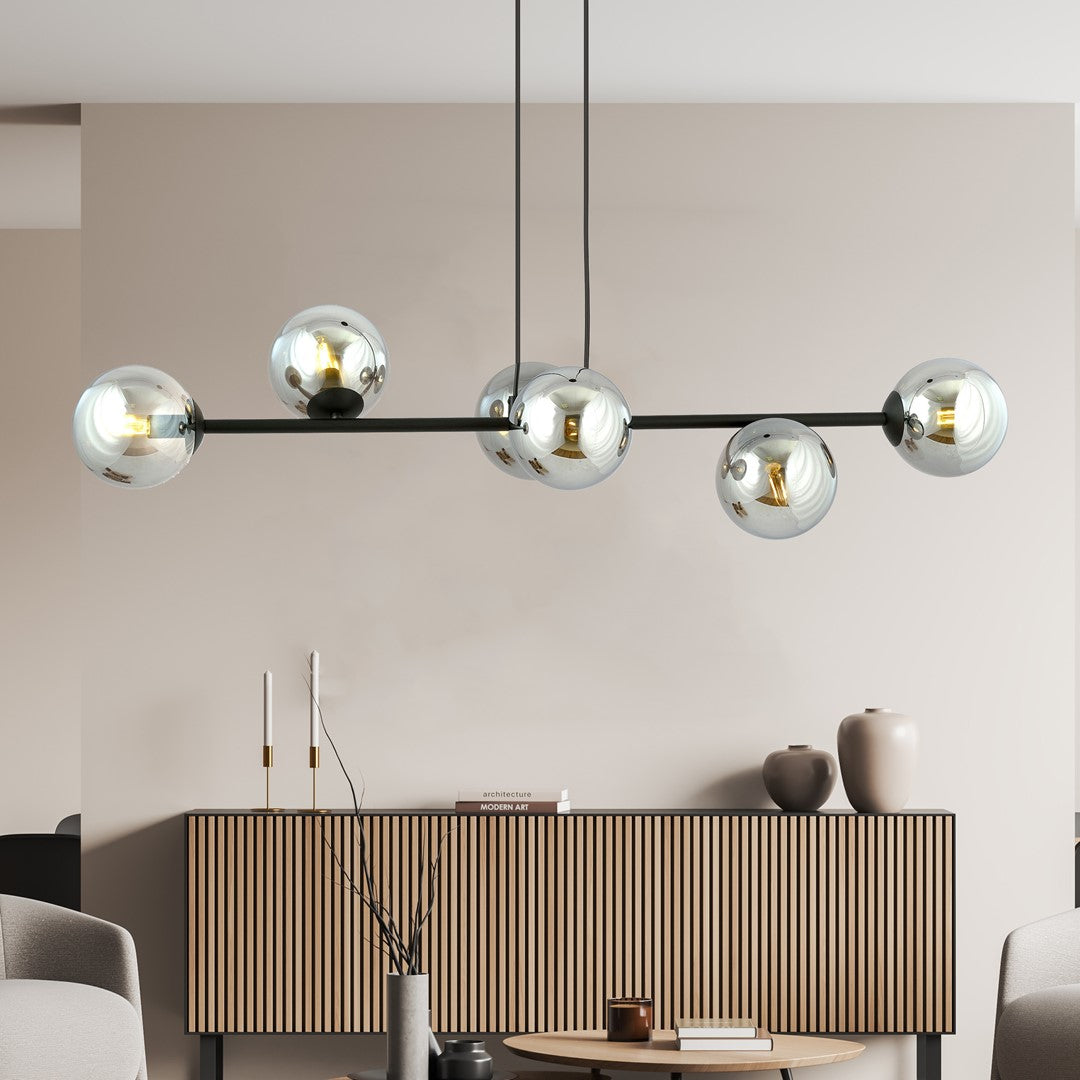 Mise en ambiance du luminaire au-dessus d'un buffet en bois dans un salon clair