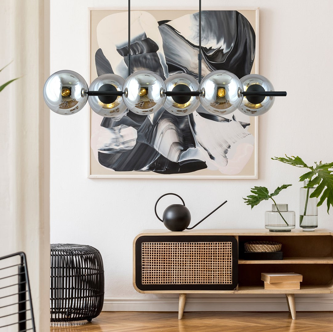 Mise en ambiance au-dessus d'un meuble cannage devant une toile abstraite