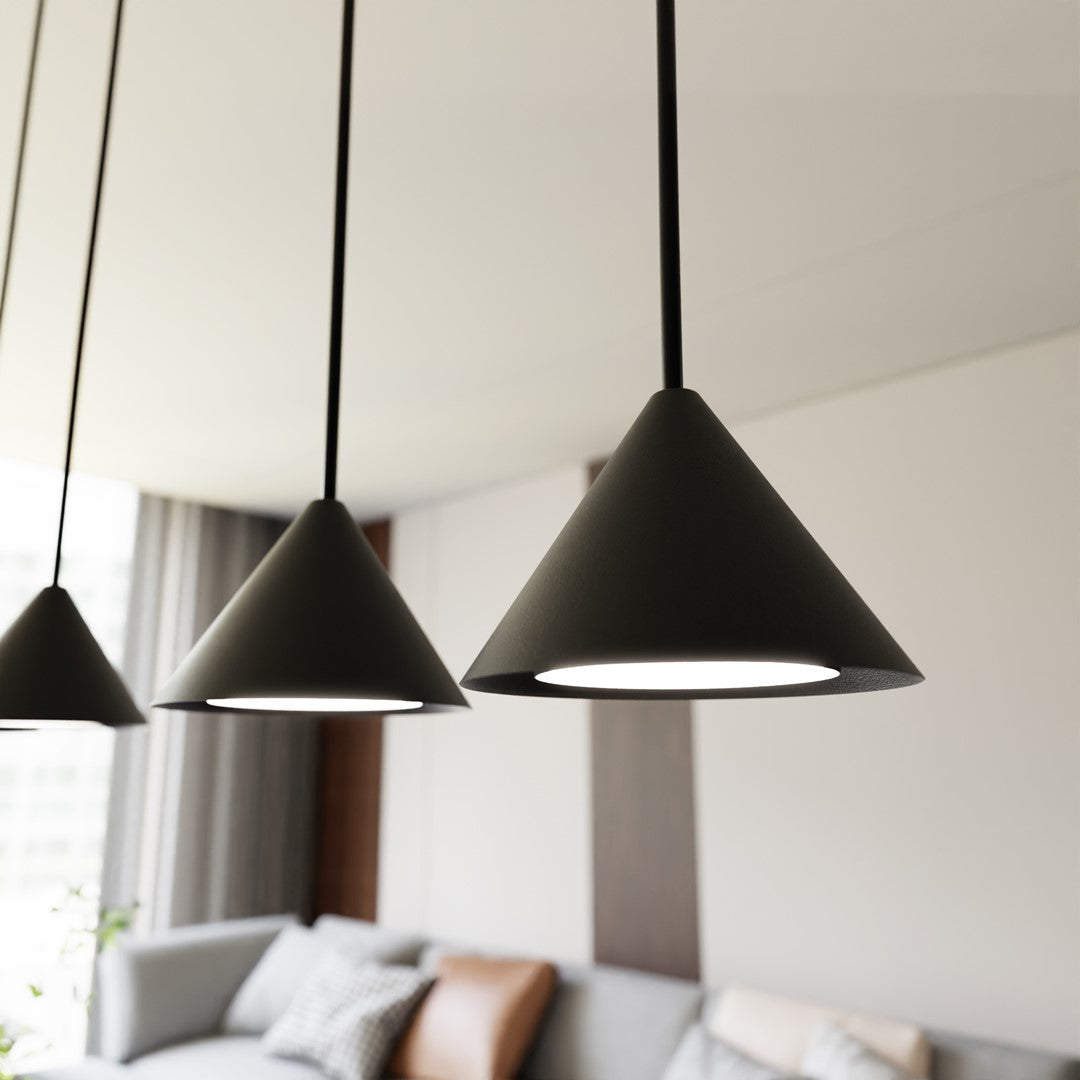 Gros plan sur trois abat-jours coniques noirs allumés, intérieur chaleureux flou.