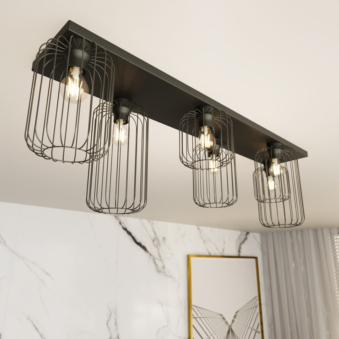 Détail rapproché des cages métalliques et ampoules allumées sous le support noir.