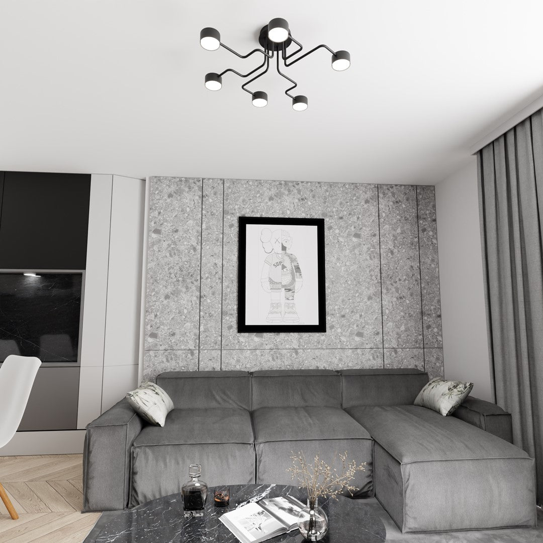Le luminaire noir illumine un salon contemporain avec canapé gris, mur béton et cadre noir.