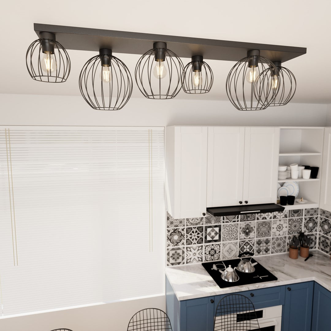 Ambiance cuisine rapprochée, luminaire allumé au-dessus du plan de travail carrelé