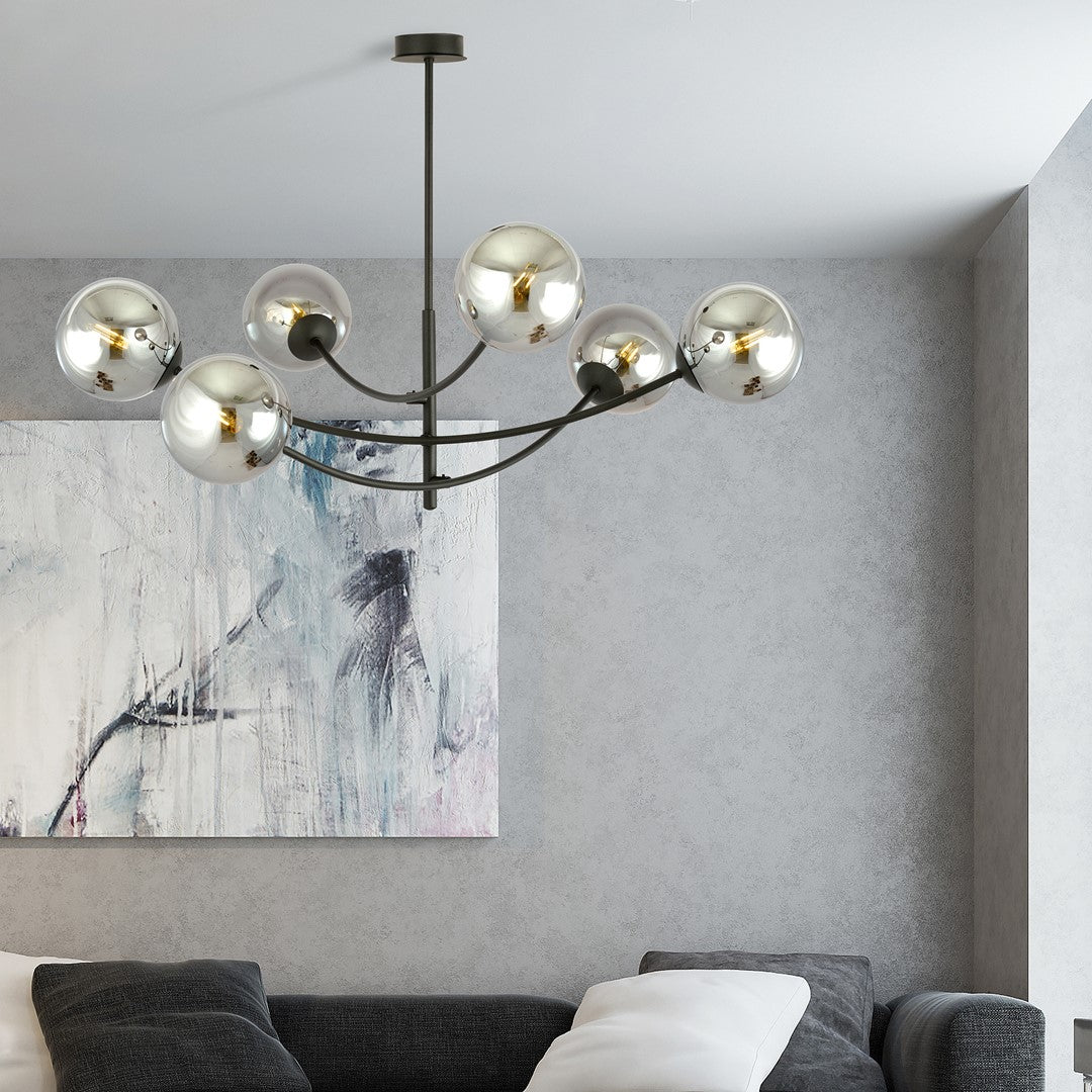 Plafonnier allumé au-dessus d'un canapé gris, toile abstraite au mur