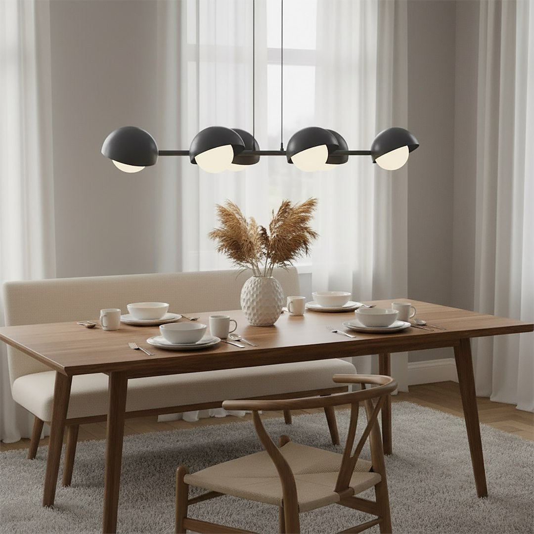 Mise en ambiance au-dessus d'une table à manger, luminaire allumé dans un intérieur.