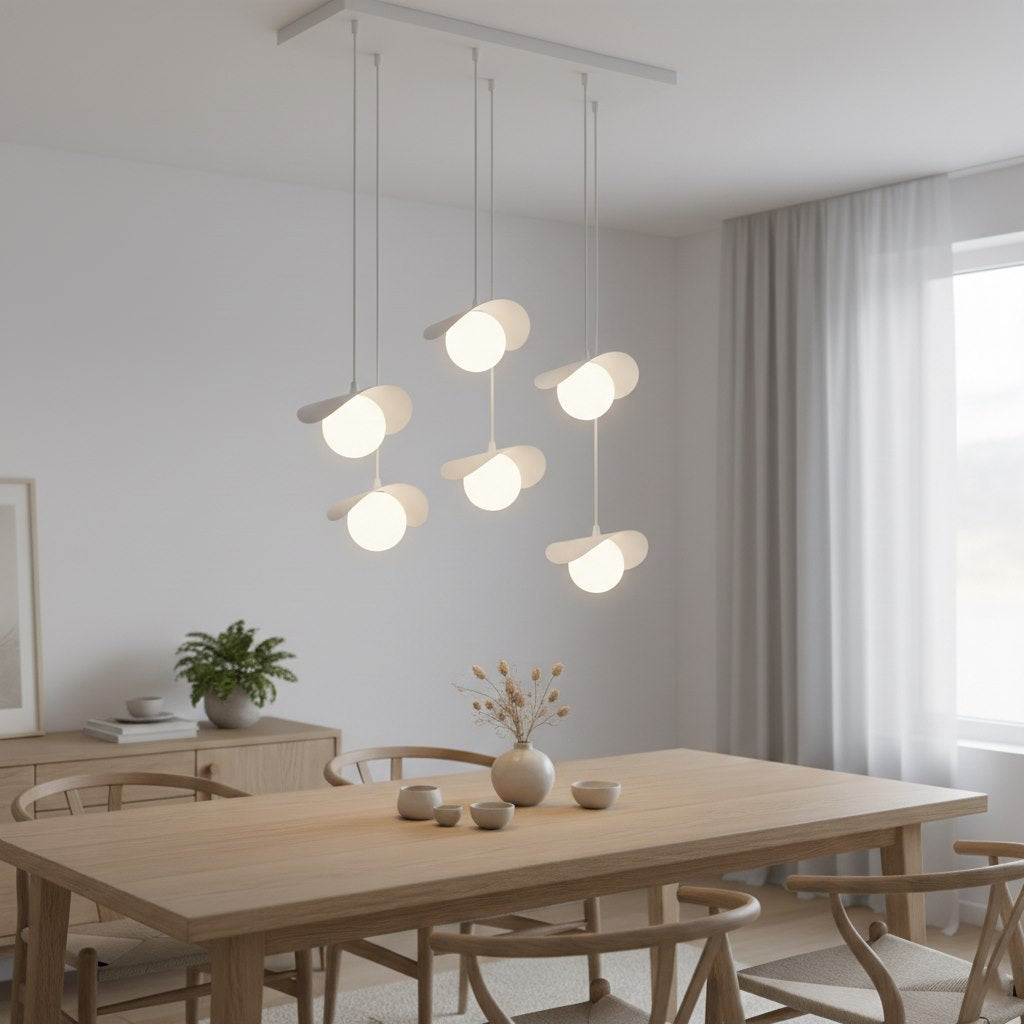 Suspension allumée éclairant une table rectangulaire, intérieur épuré avec plante et rideaux