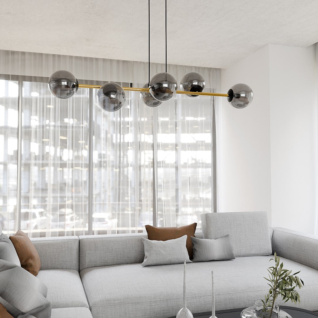 Suspension allumée au-dessus d'un canapé gris, ambiance salon lumineuse et épurée