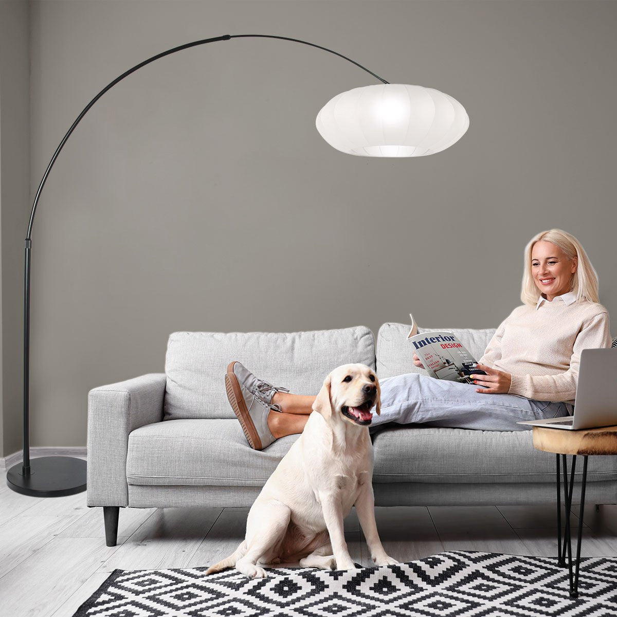 Mise en situation, femme lisant sur un canapé gris sous le lampadaire