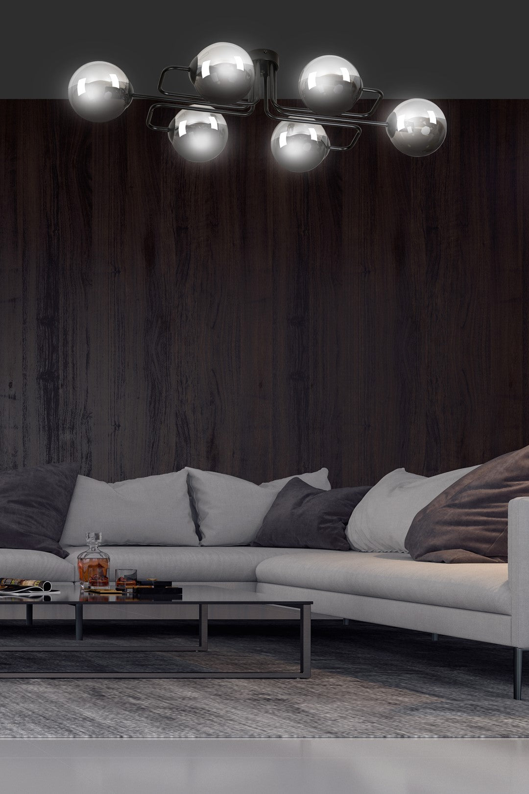 Mise en ambiance salon sombre avec canapé gris et mur bois