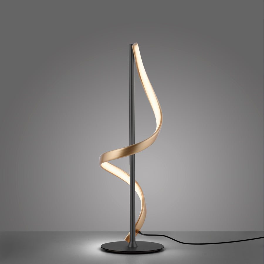 Lampe à poser branchée sur fond gris foncé, câble d'alimentation visible.