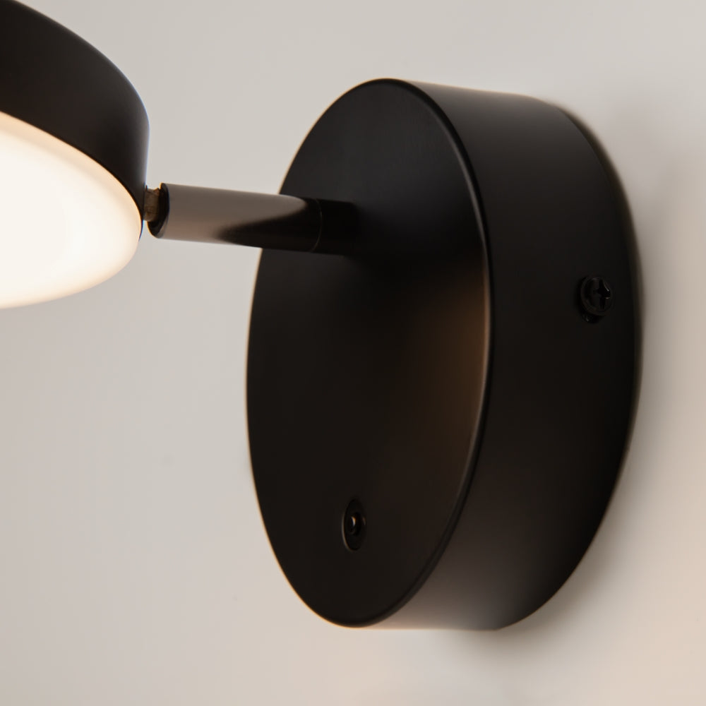 Détail de la base murale noire, bras orientable et interrupteur intégré en gros plan