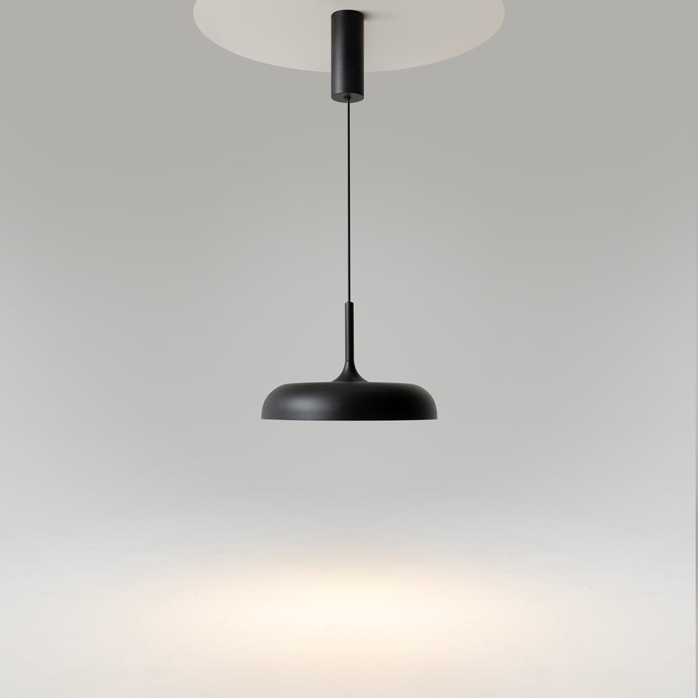 Suspension noire éteinte vue de dessous, câble tendu devant un plafond clair.