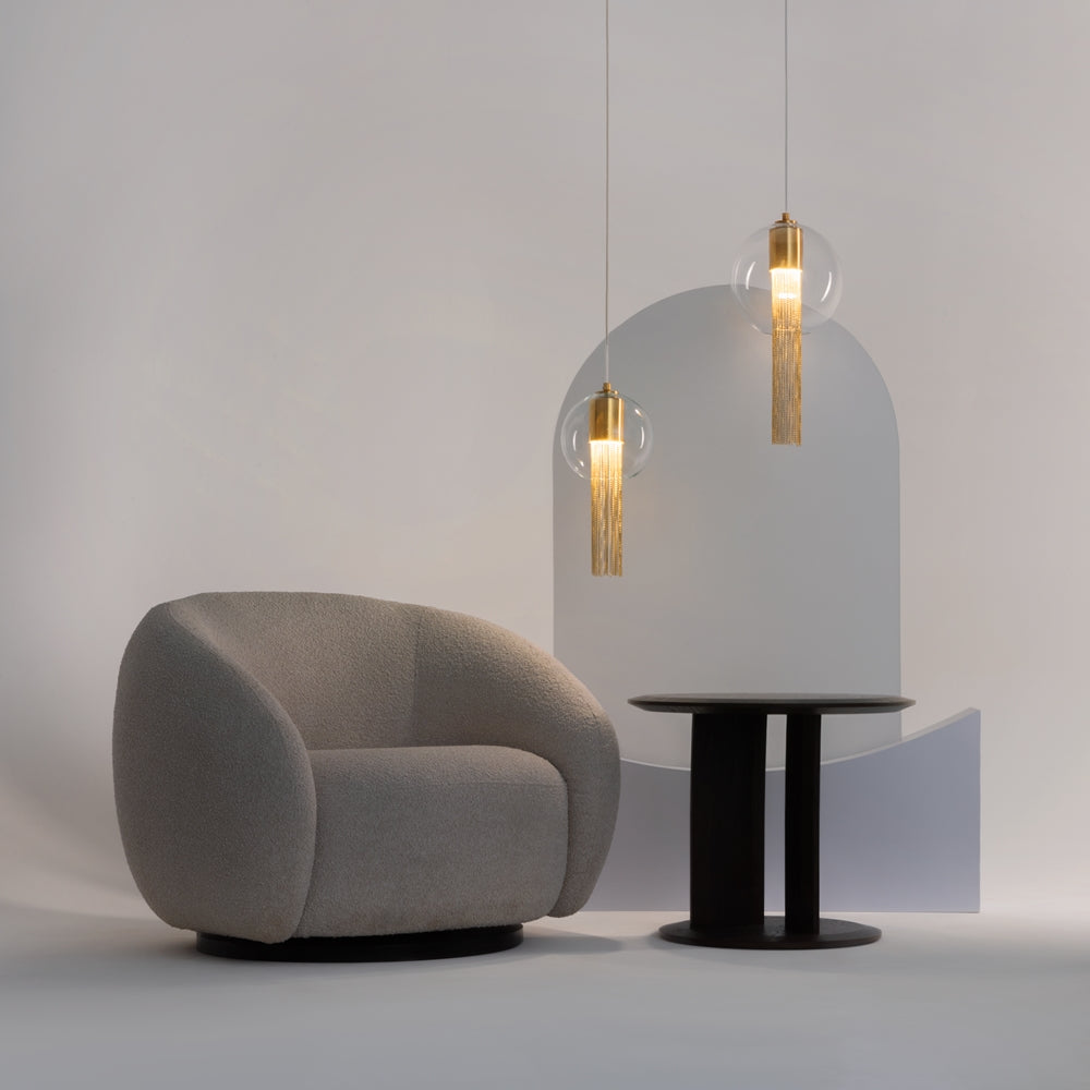 Mise en ambiance intérieure avec deux suspensions au-dessus d'une table et d'un fauteuil