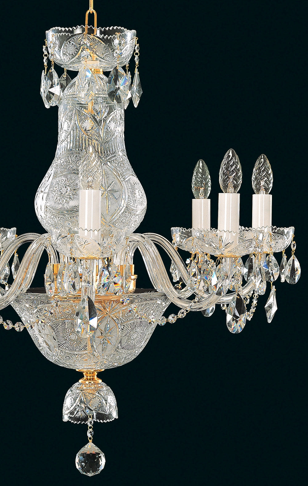 Gros plan sur le sommet ouvragé et un bras recourbé du lustre