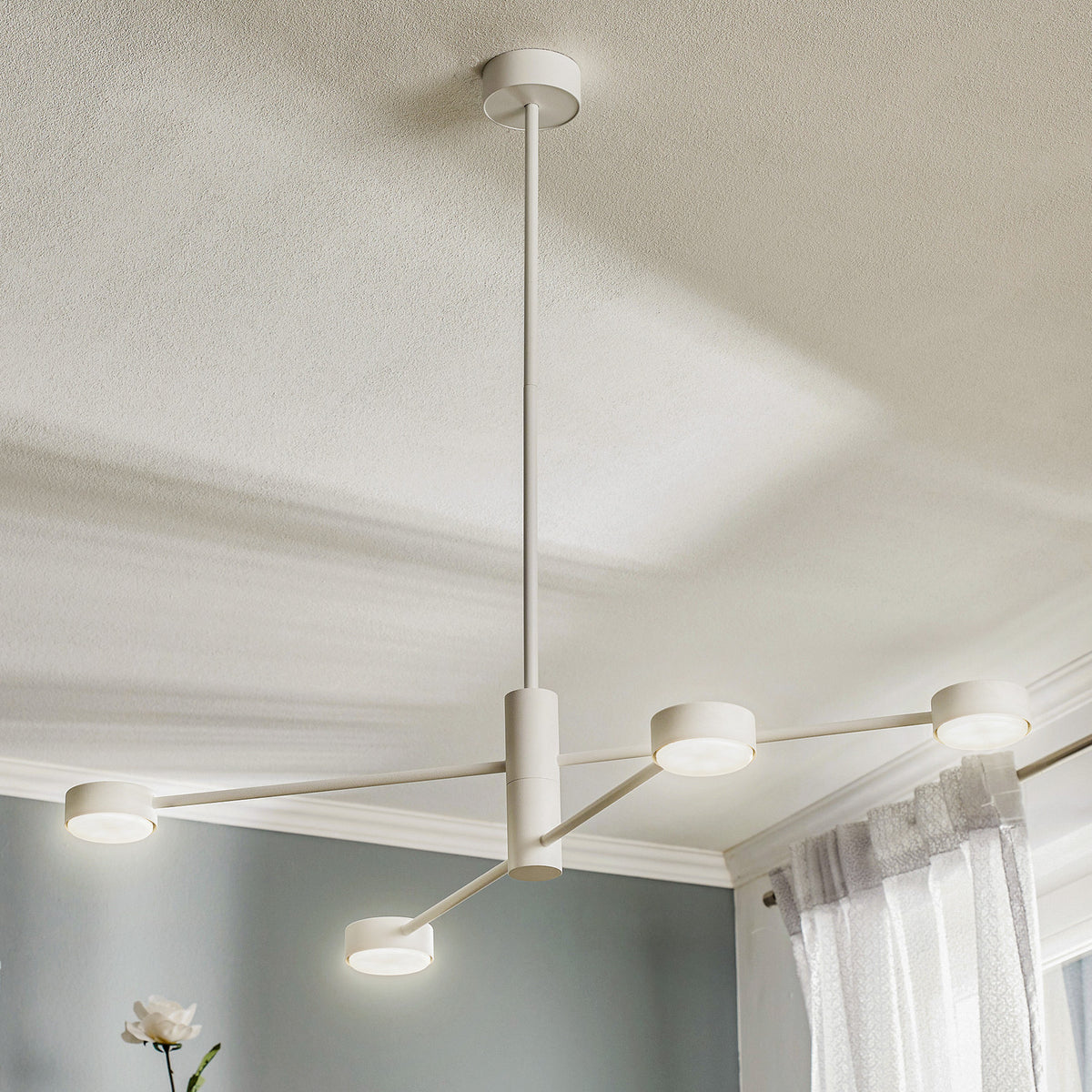 Vue en plongée du luminaire suspendu blanc allumé dans un intérieur clair