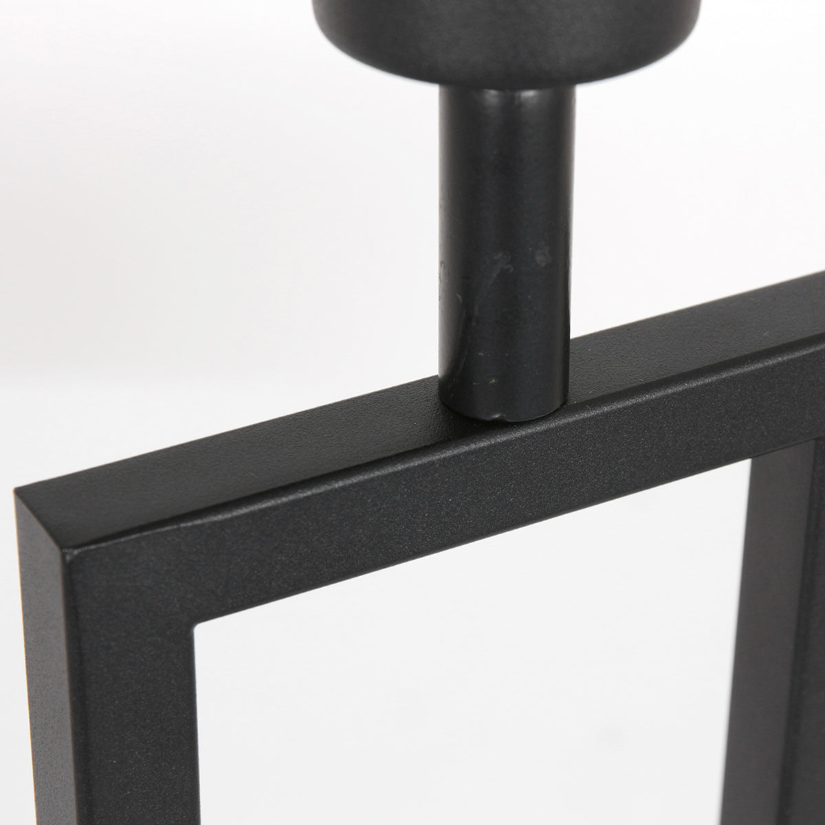 Détail de l'assemblage entre le tube vertical et le cadre rectangulaire noir.