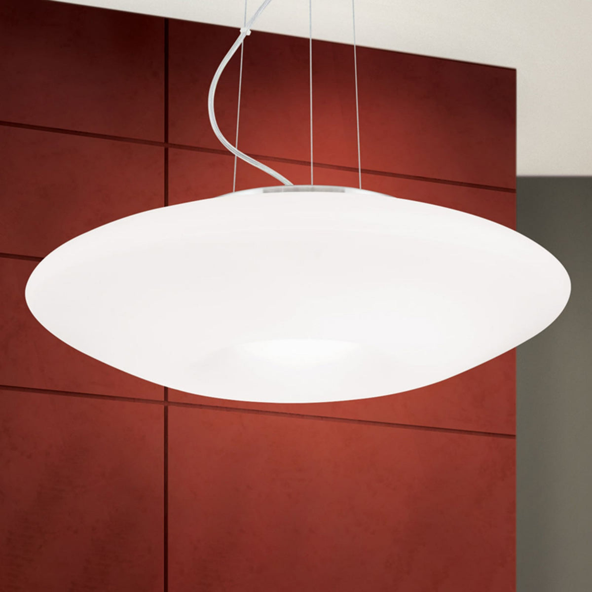 Vue rapprochée du diffuseur ovale blanc et des câbles de suspension.