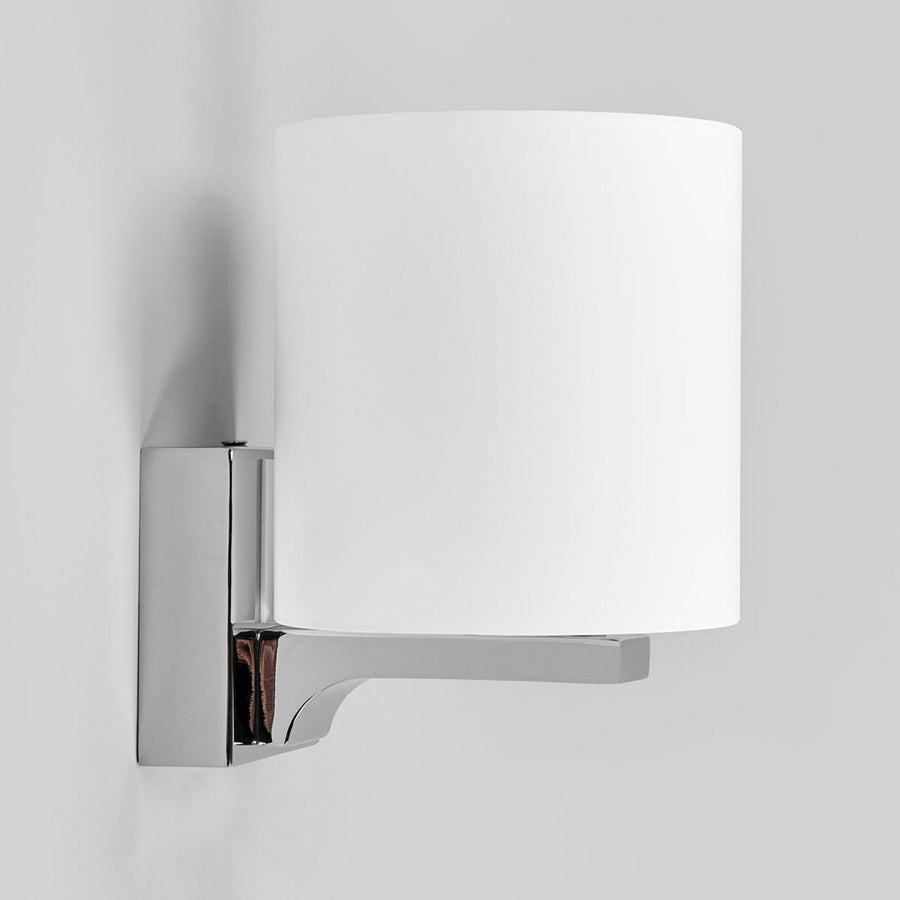 Vue de côté de l'applique murale chromée et de son abat-jour cylindrique blanc