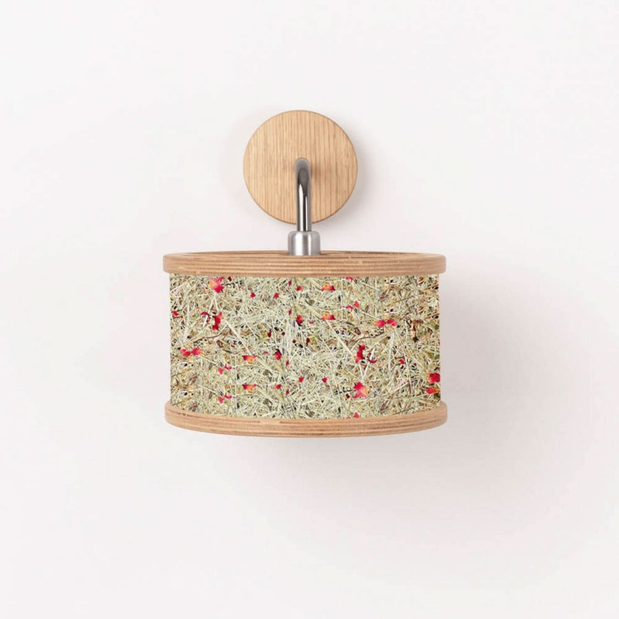 Applique murale présentée de face, abat-jour cylindrique en fibres végétales et fleurs rouges