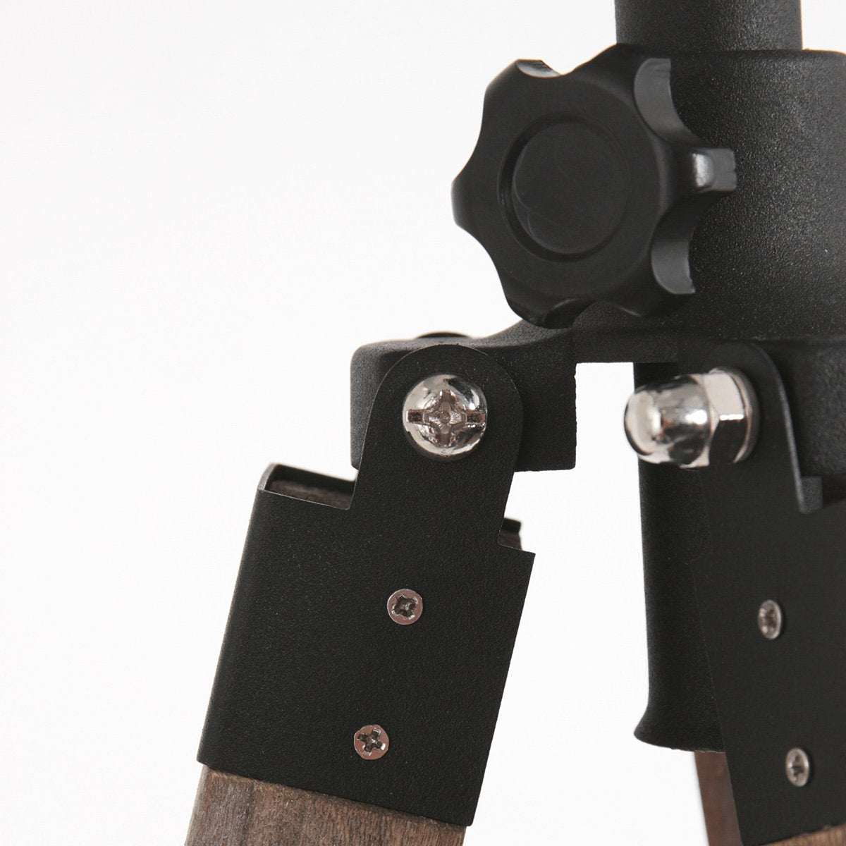Détail rapproché de l'articulation métallique et des vis maintenant les pieds en bois.