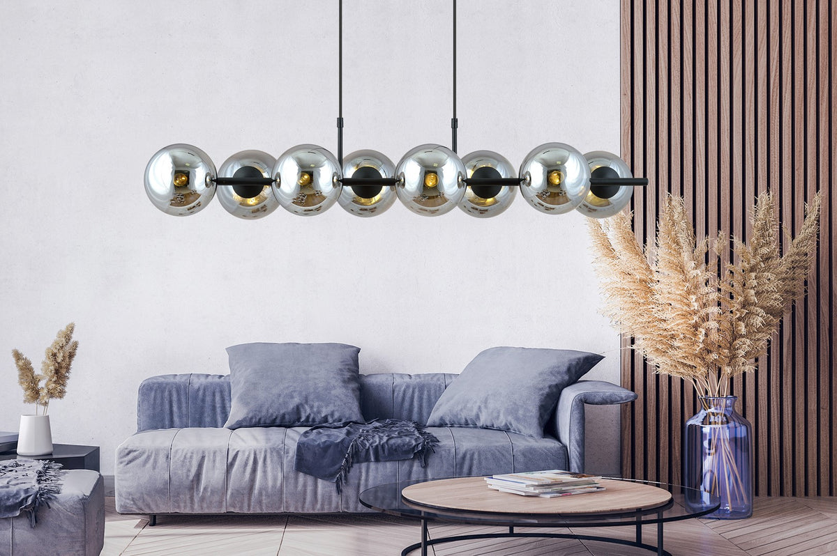 Salon contemporain avec canapé gris, le luminaire à globes suspendu devant un mur lambrissé de bois