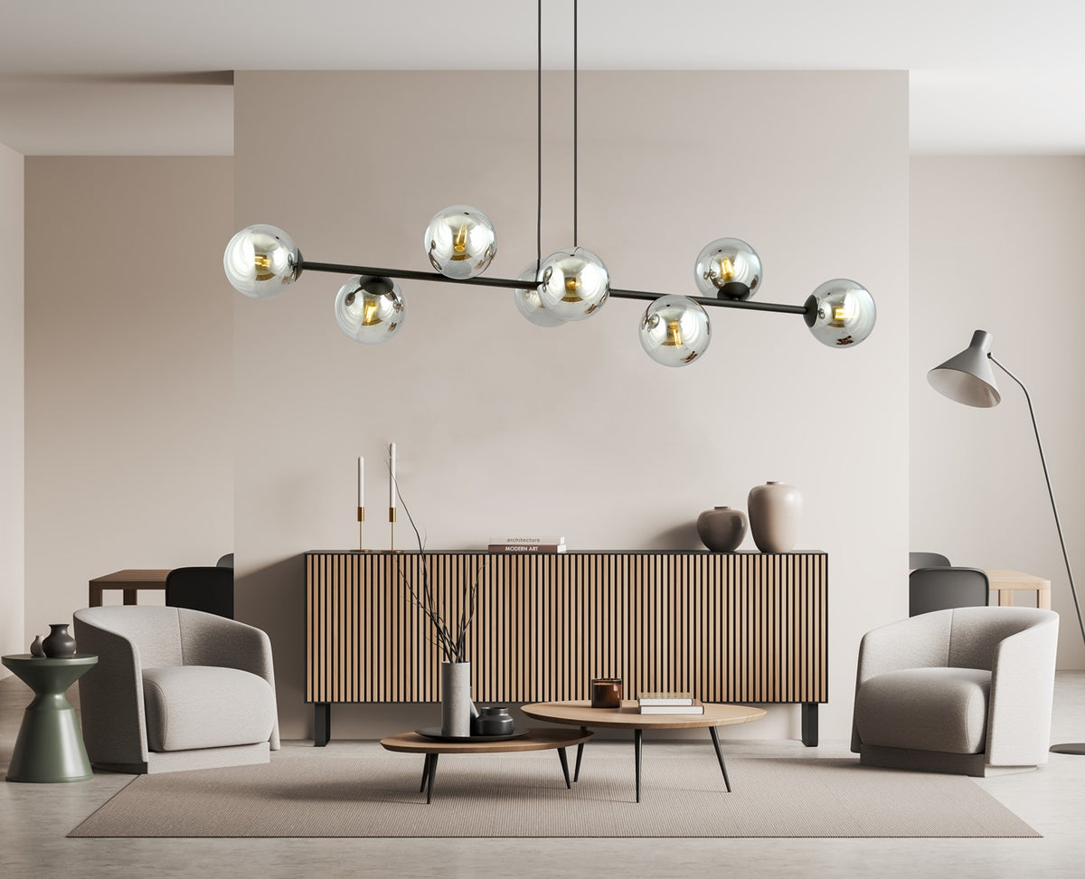 Mise en ambiance du luminaire suspendu au-dessus d'un meuble à rayures dans un salon.