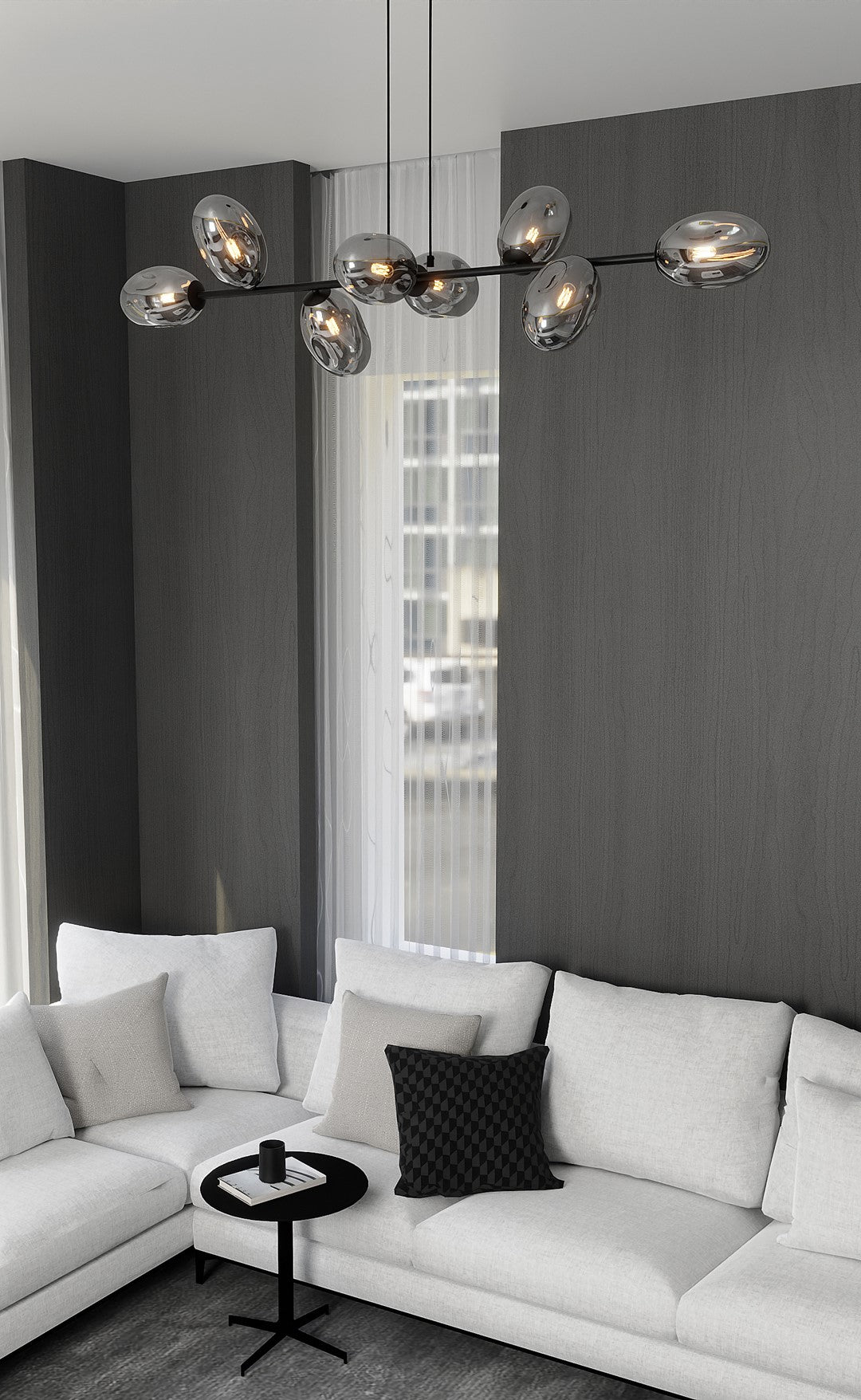 Mise en ambiance salon contemporain, suspension allumée au-dessus d'un canapé blanc et mur gris