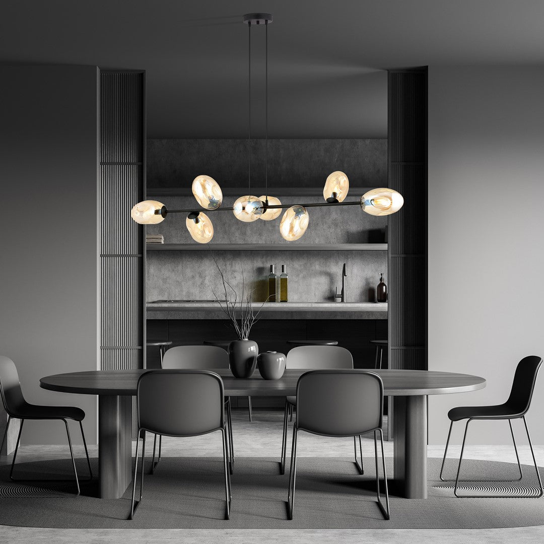 Suspension installée au-dessus d'une table de salle à manger, éclairage chaleureux dans un décor gris.