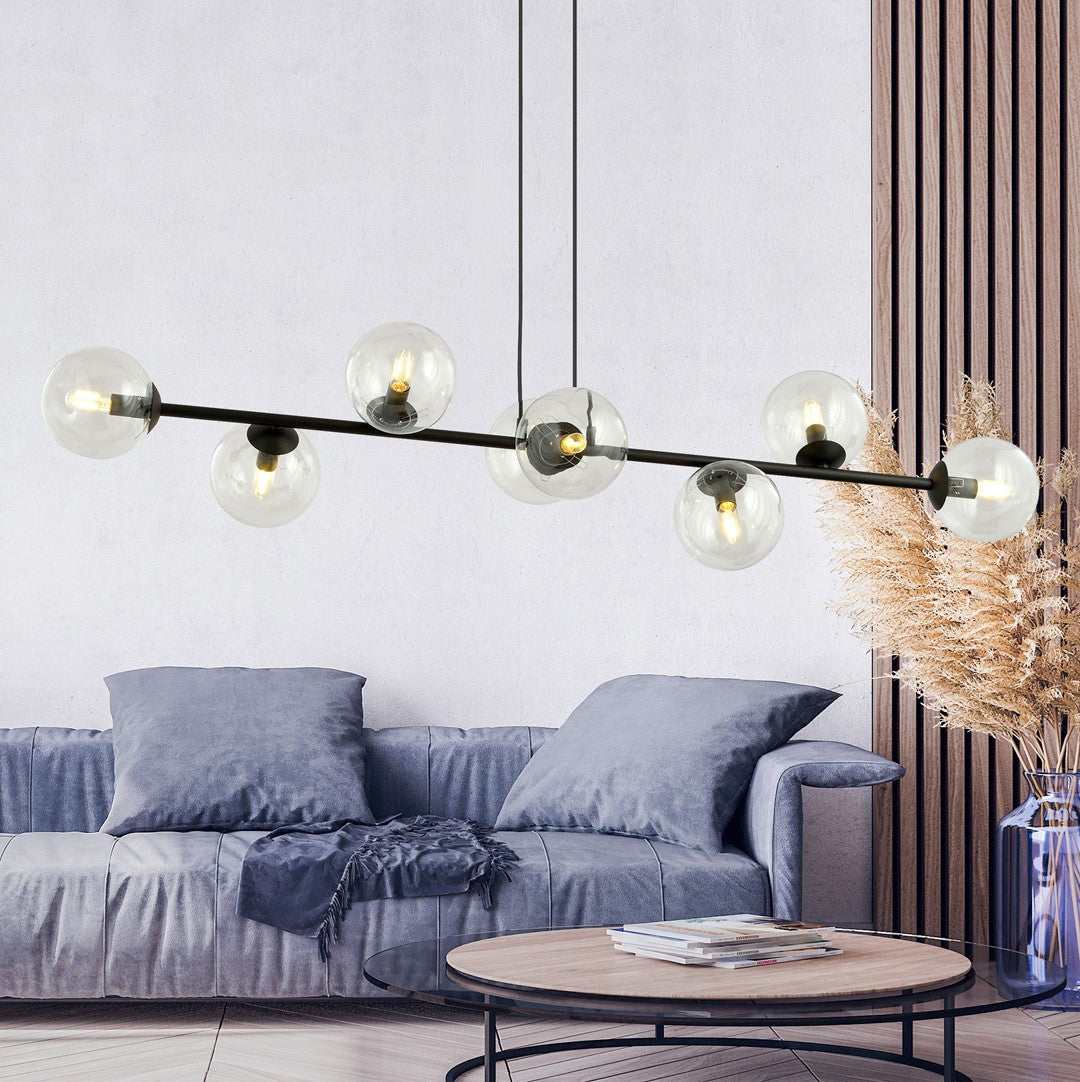 Mise en scène du luminaire suspendu au-dessus d'un salon moderne avec canapé bleu et table basse.